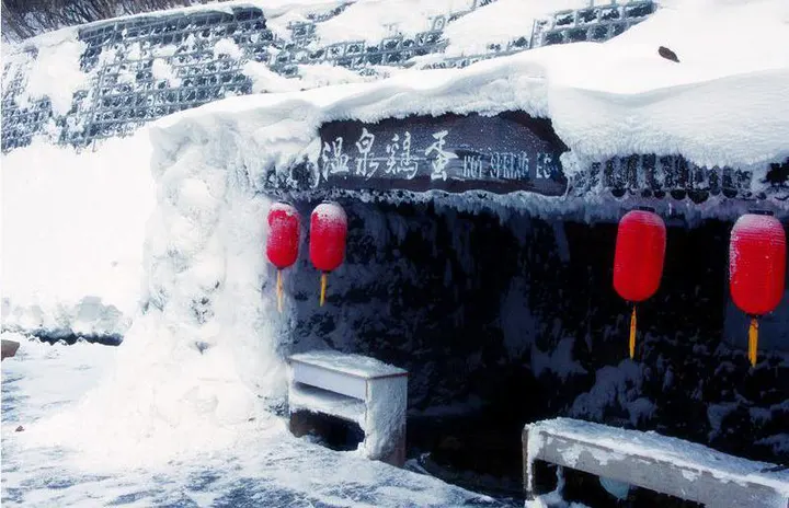 温泉鸡蛋摊：雪压着屋檐，四个红灯笼，招牌上的字被冰挂住了一半