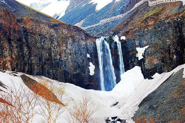 初冬的长白瀑布：水还没冻实，雪已经压到崖脚