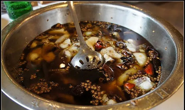 A beef-tallow base, Sichuan pepper floating on top, thickening as it cooks