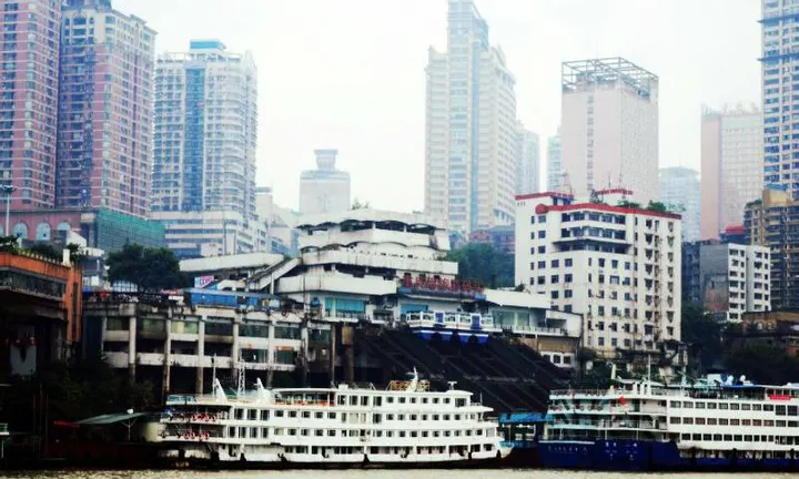 Chaotianmen wharf, cruise boats below a wall of buildings