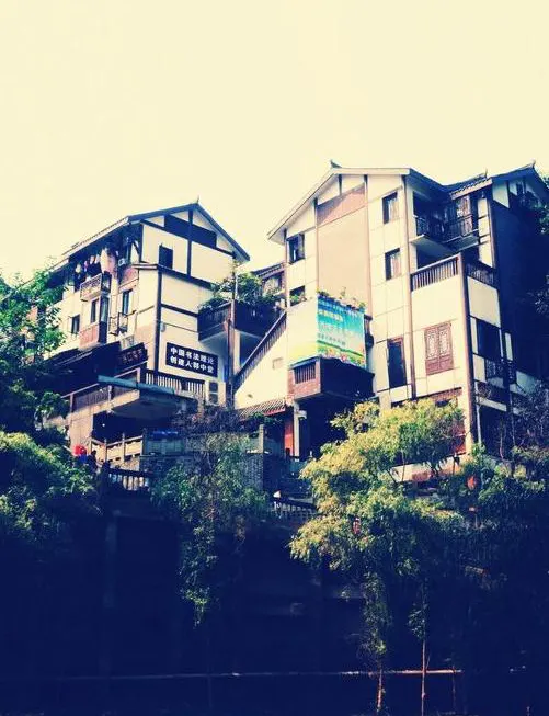 Old stilt houses stacked against the cliff, a slope below