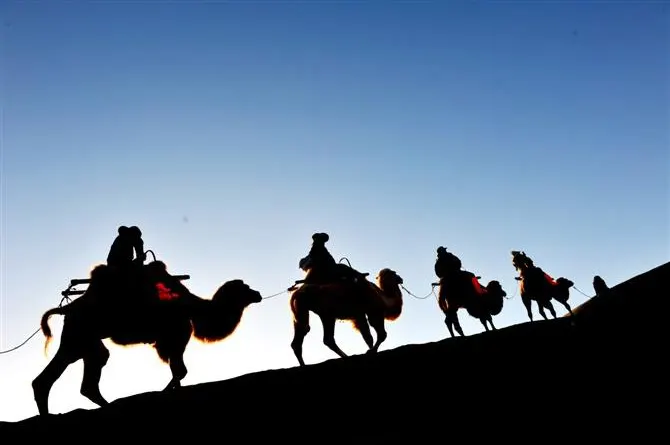 Last light: the caravan reduced to silhouettes