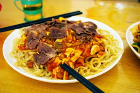 Donkey-meat yellow noodles, sliced braised meat over a plate of fine noodles