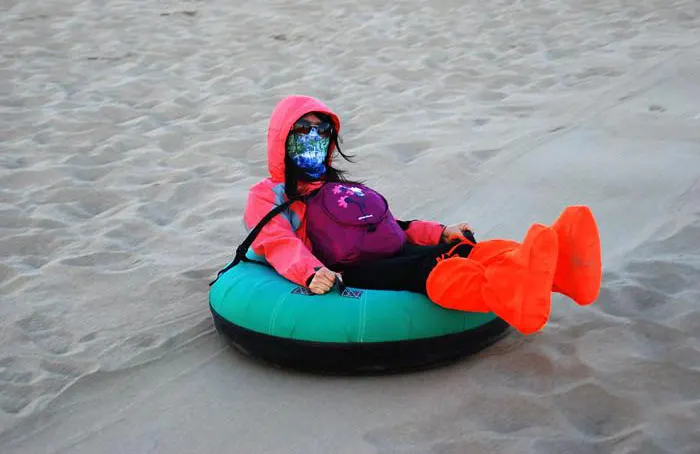 Sliding down a dune on an inflatable sled