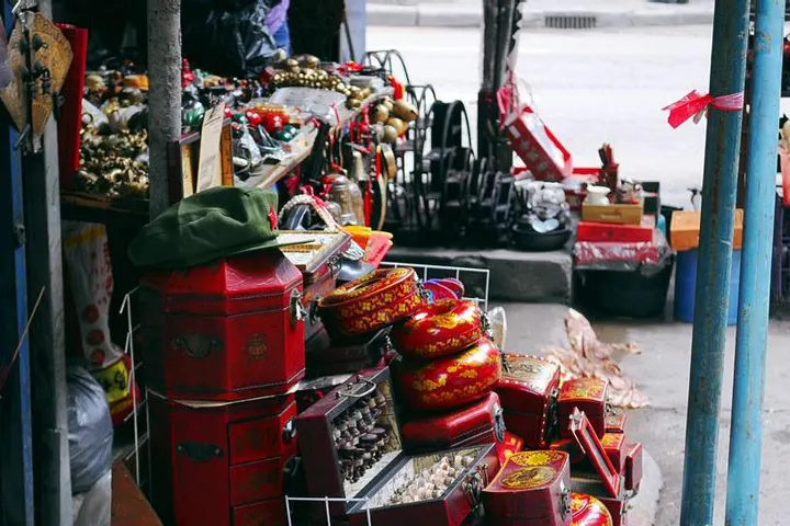 A pavement stall of lacquer boxes and old brass