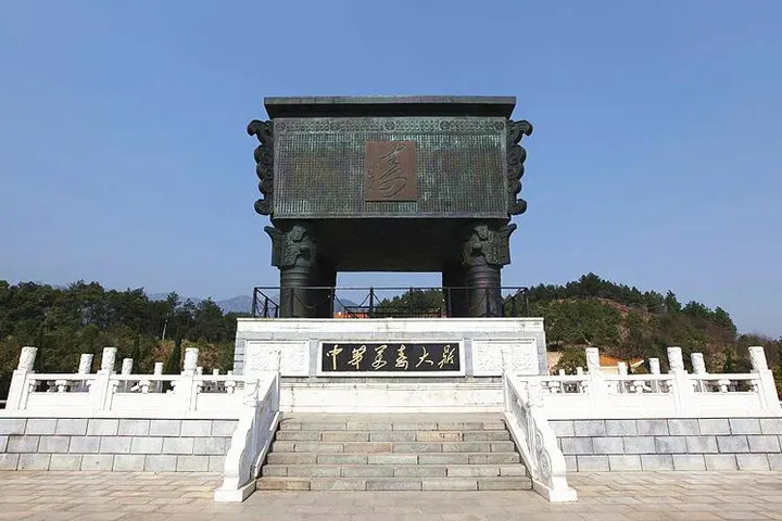 万寿广场上的大鼎：长方形铜鼎坐在四条粗腿上，正面一个凸起的“寿”字，下面白石台基刻“中华万寿大鼎”，背后是蓝天和低山