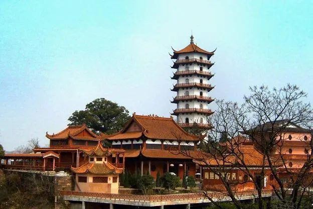 南台寺与金刚舍利塔：橙黄屋顶的殿宇在前面铺开，九层八角塔立在后面，天是淡青色的