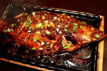 Braised stinky mandarin fish: deep sauce, flesh in flakes, a handful of spring onion on top