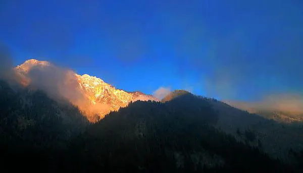 Before sunset the light reaches only the highest ridge; the valley floor is already dark