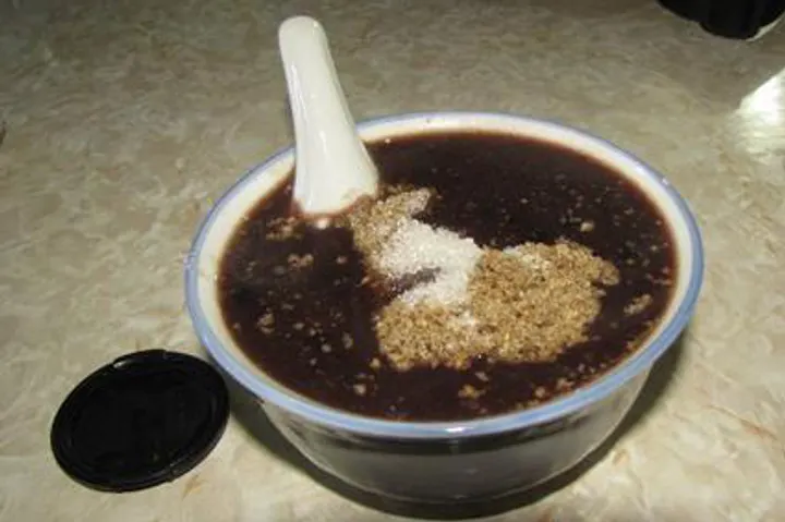 Grey-pea porridge, thick and dark, finished with a spoon of sugar