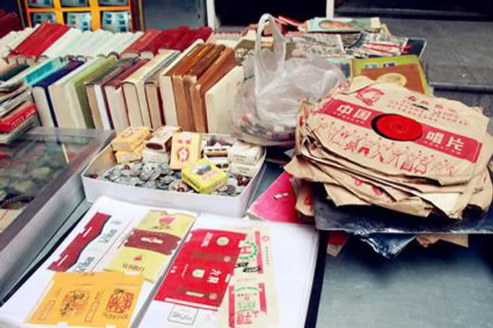 An antique stall at the City God Temple: old books, cigarette packets, stamps and stacks of vintage paper