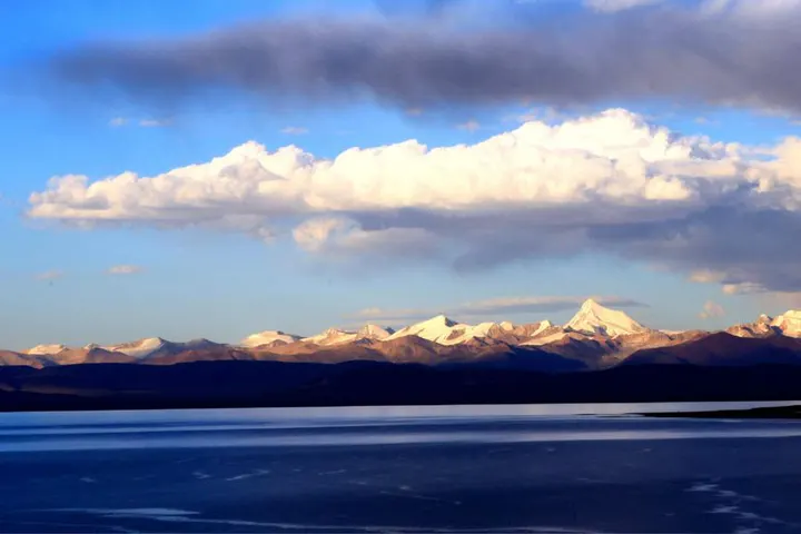 Evening on the water, the snowline on the far shore, the last sun turning the cloud pink
