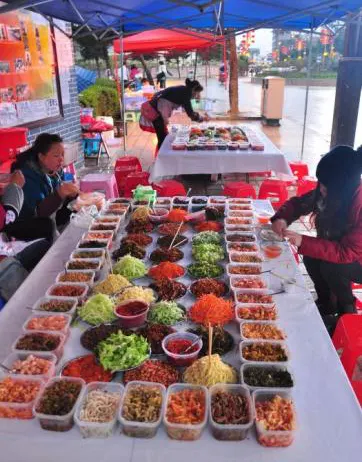 A siwawa stall at the night market: bowls of fillings laid out, wrappers stacked, customers rolling their own