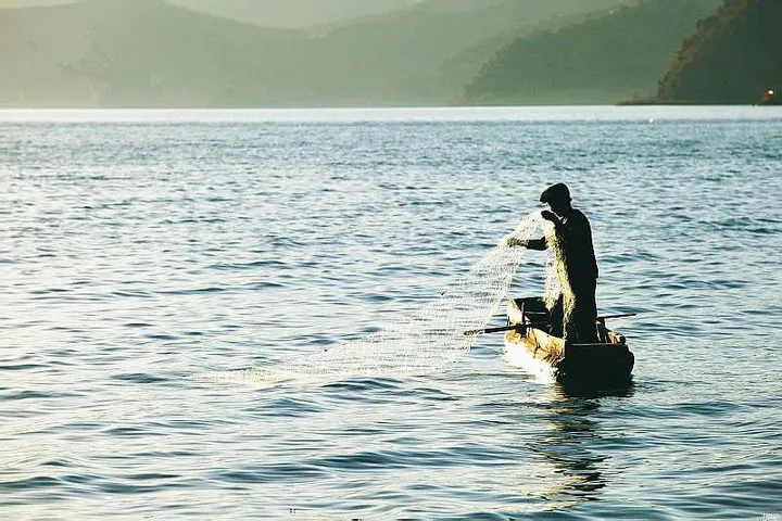 Morning work on the lake: one man, one net, one small boat