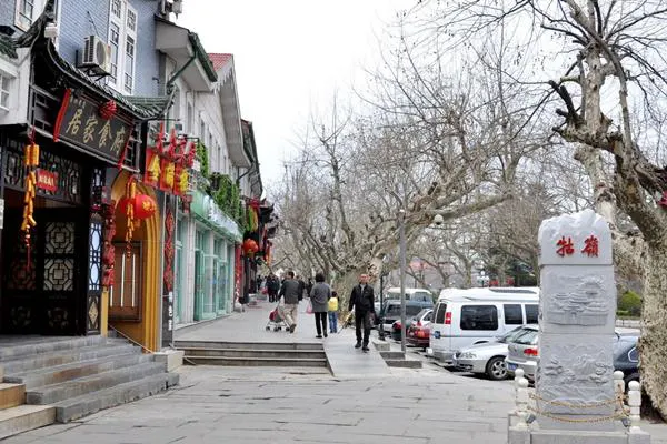 Guling Street — flagstones, plane trees, shops selling mountain produce, and a stone marker carved with the town's name