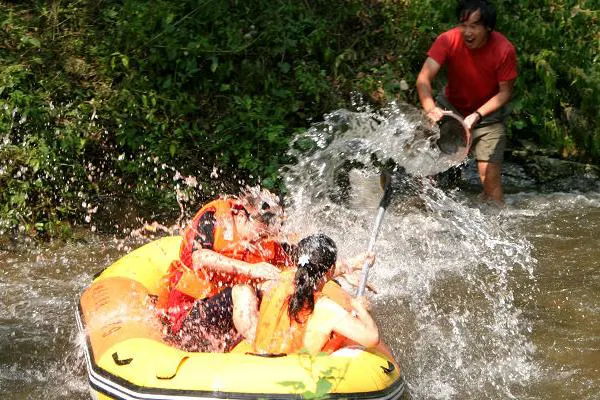 Rafting — a yellow boat, orange life vests, and two people already soaked