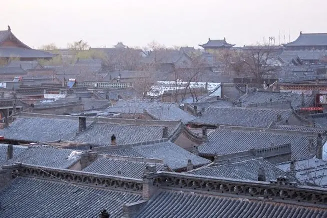 Grey tile roofs, courtyard after courtyard, seen from above