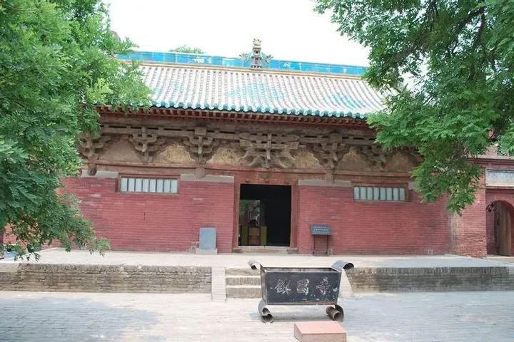 A hall at one of the temples outside the walls: red brick, glazed tile eaves, an iron censer in the yard