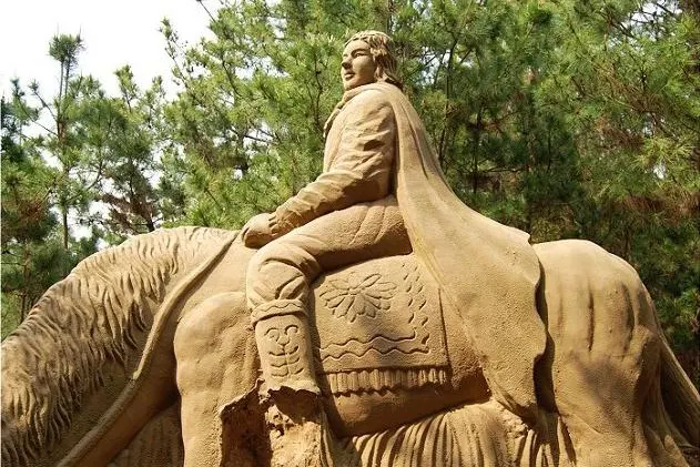 A sand sculpture on the beach: a rider on horseback, every detail pressed into the sand