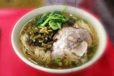 A bowl of Suzhou noodles, topping on the side
