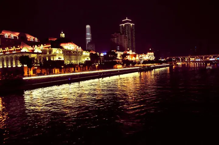 入夜后的海河，对岸的灯带一直铺到桥下