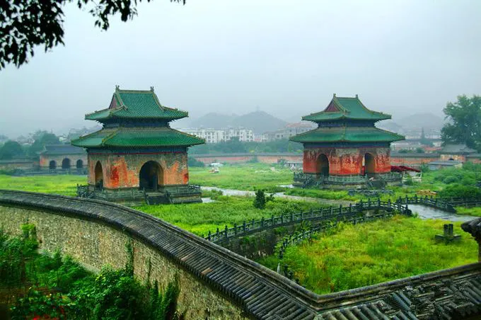 两座一模一样的绿琉璃方亭立在宫墙里的草地上，前后是低矮的瓦墙，背后是镇子的屋顶，雾还没散