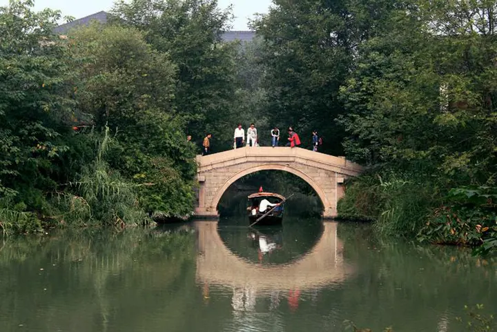 A stone arch bridge over still water