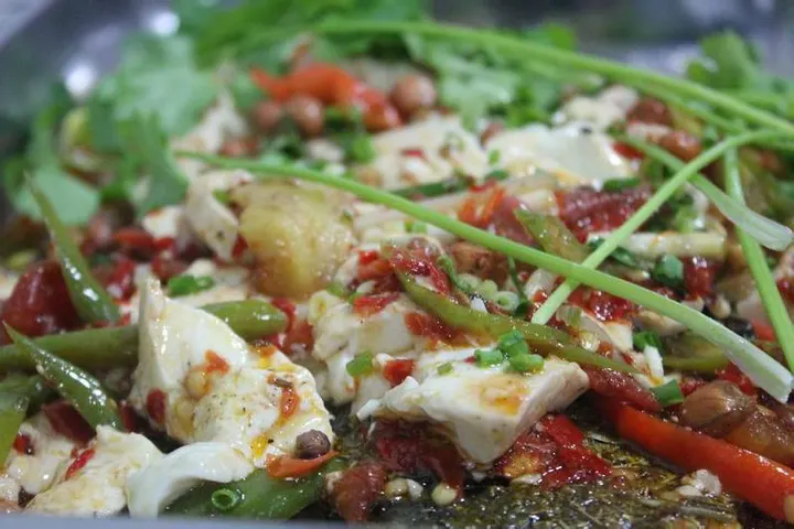Grilled fish under a layer of soft tofu curd, red broth with chilli and spring onion