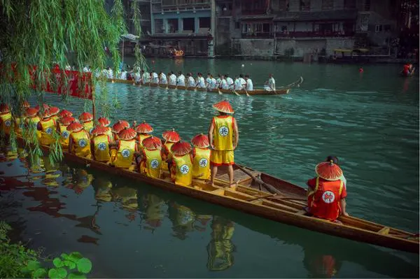 A crew in yellow, paddles halfway through the stroke