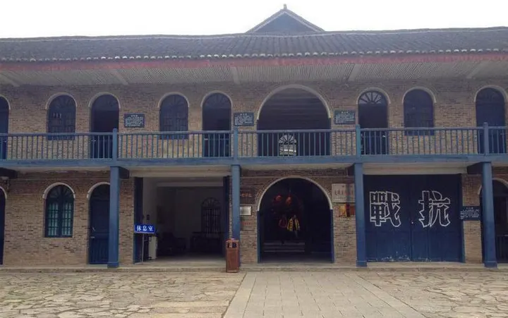 The brick building inside Heping Village: arched windows, blue timber doors, wartime lettering still on them