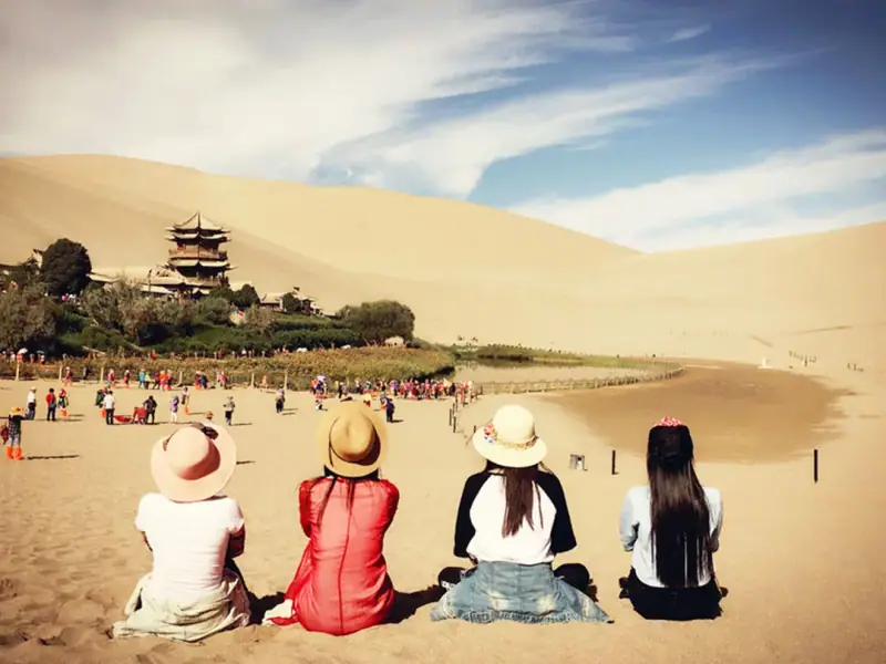 Cuevas de Mogao — Camel trains below the dunes at dusk